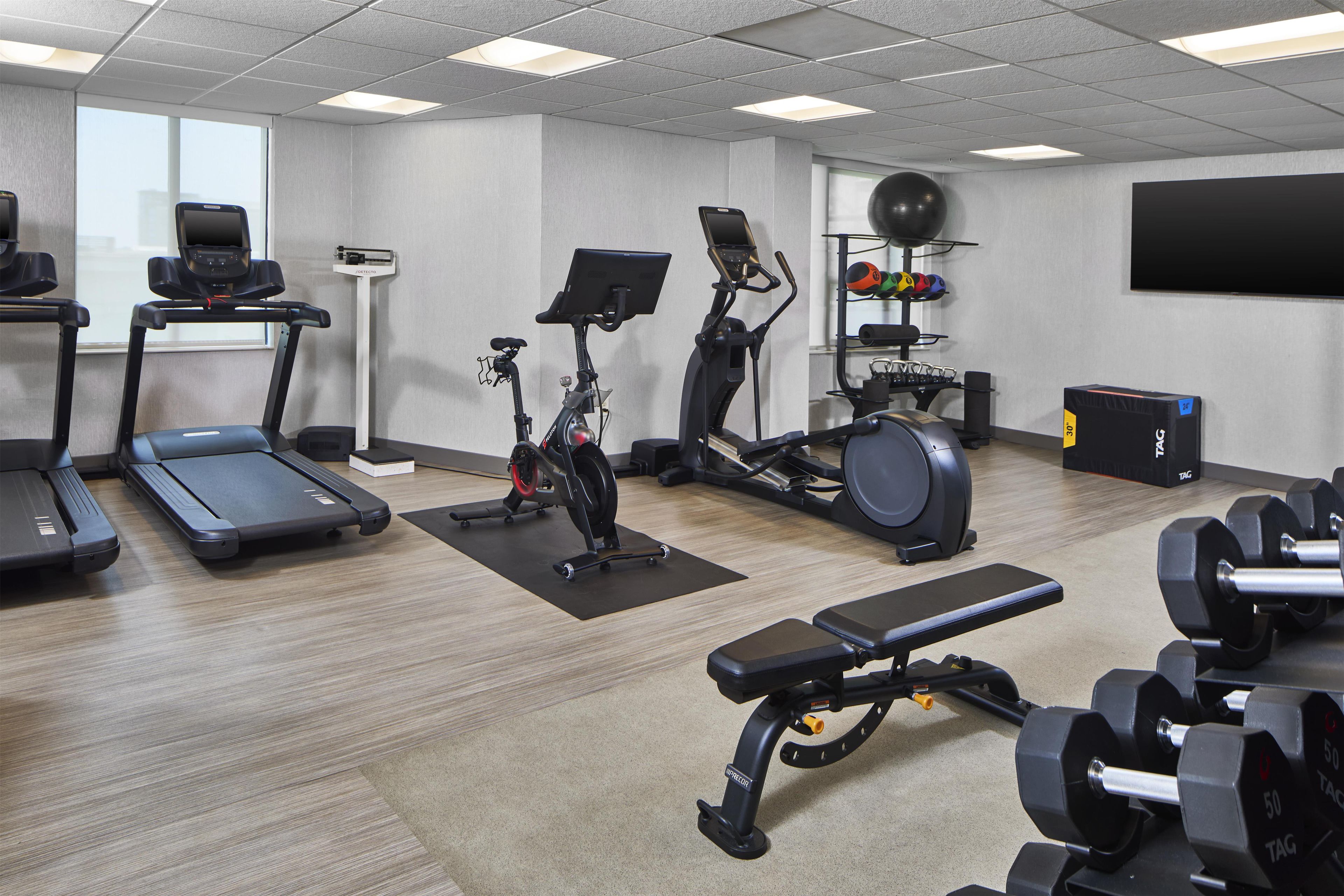 Un centre de remise en forme équipé de tapis de course, de vélos d’appartement, d’un appareil d’aviron et de poids libres.