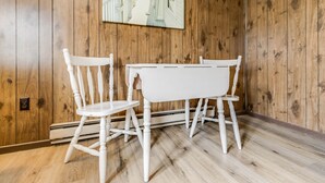 A room with wooden paneled walls and a white table with two chairs. - The Inn at Lewes (Lewes)