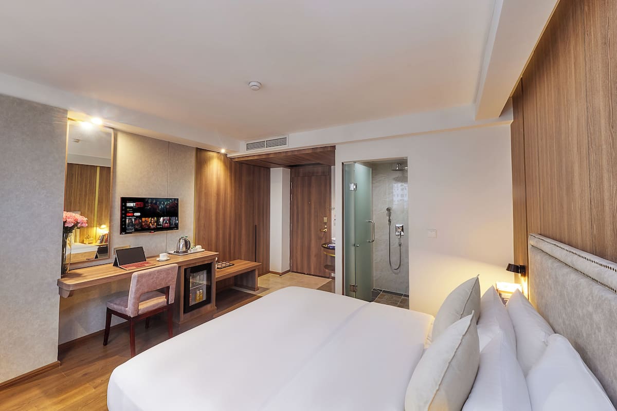 Habitación individual Deluxe | Minibar, caja de seguridad en la habitación y muebles diferentes