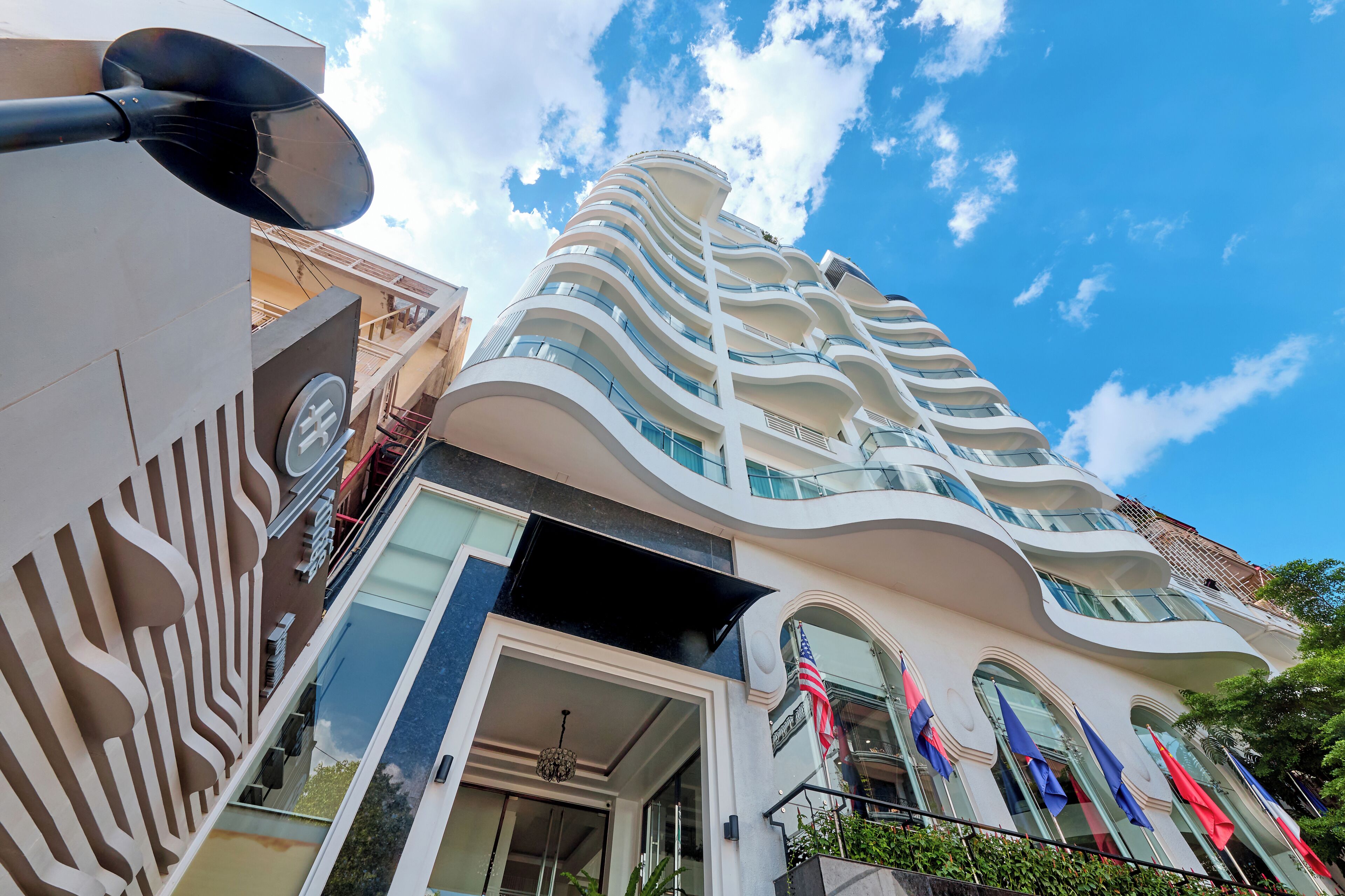 A modern hotel with a unique curved architecture, large windows, and an American flag.