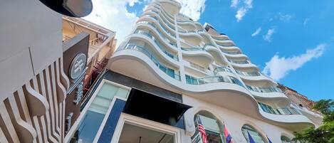A modern hotel with a unique curved architecture, large windows, and an American flag.