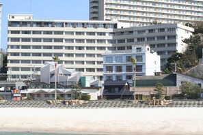 A multi-story hotel with a modern design, featuring balconies and a beach view. - Hotel Sanrakuso (Shirahama)