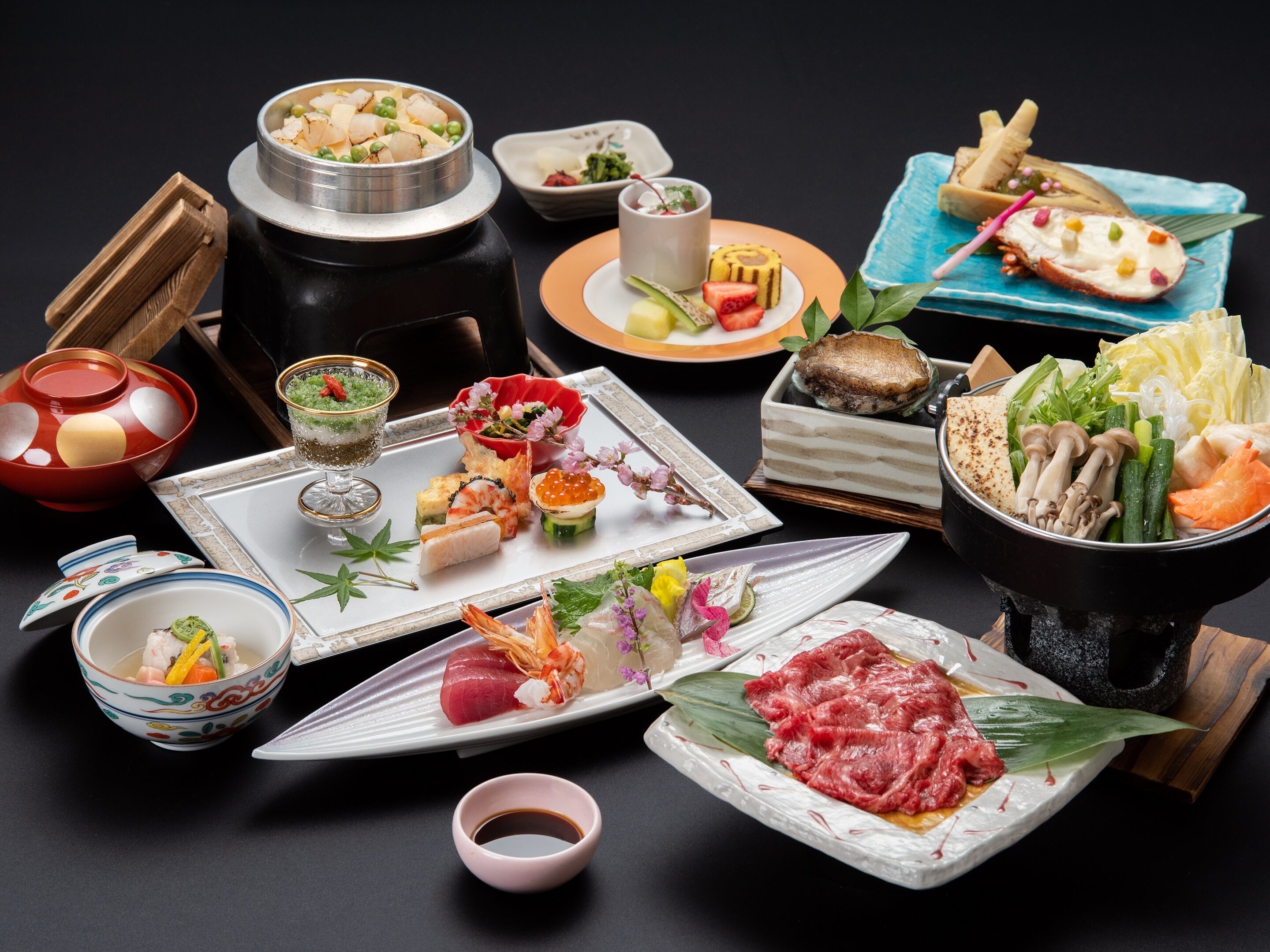 A variety of Japanese dishes including sushi, sashimi, and tempura, served on traditional ceramic plates and bowls.