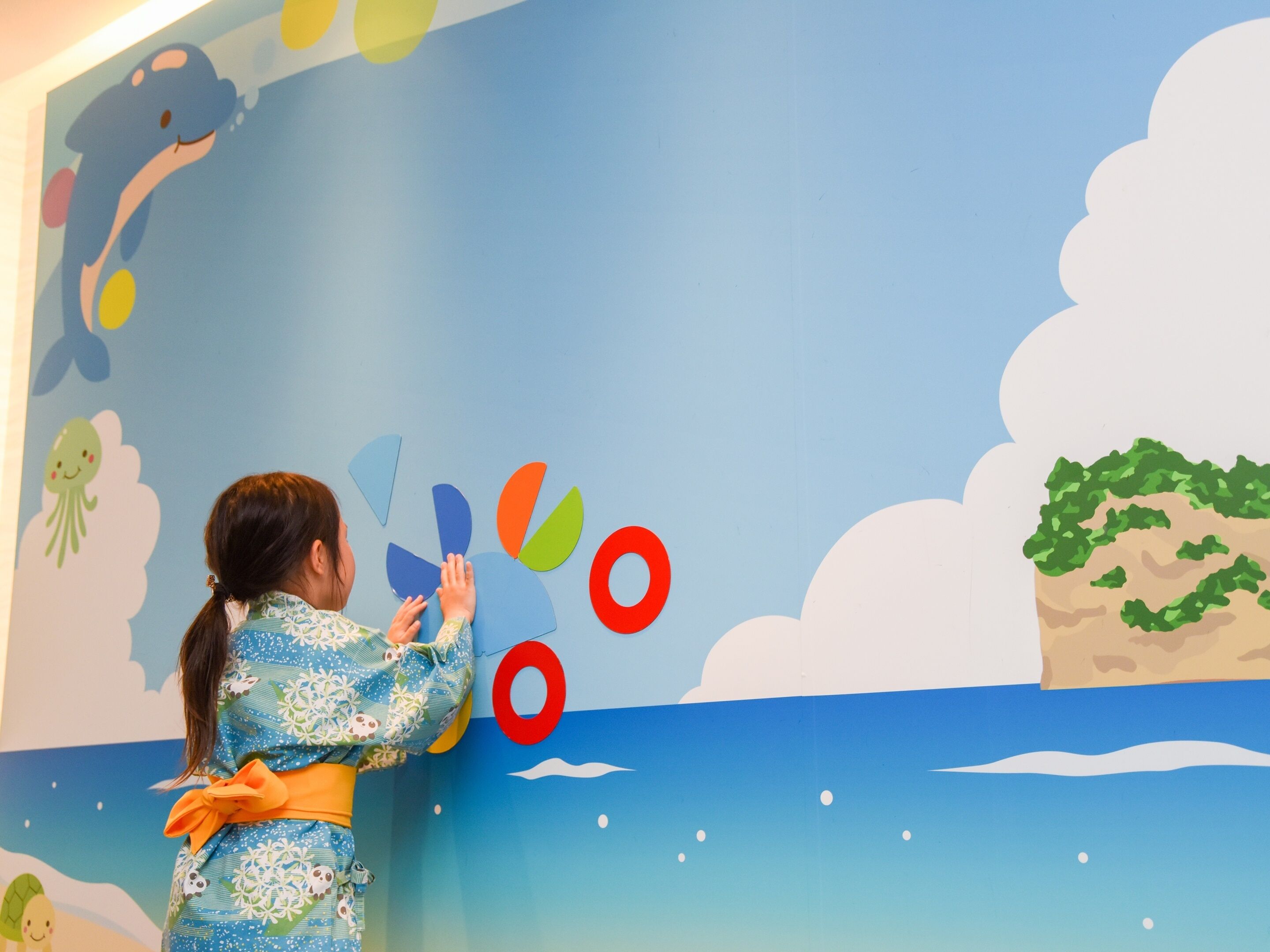 Un enfant interagissant avec une fresque murale colorée.