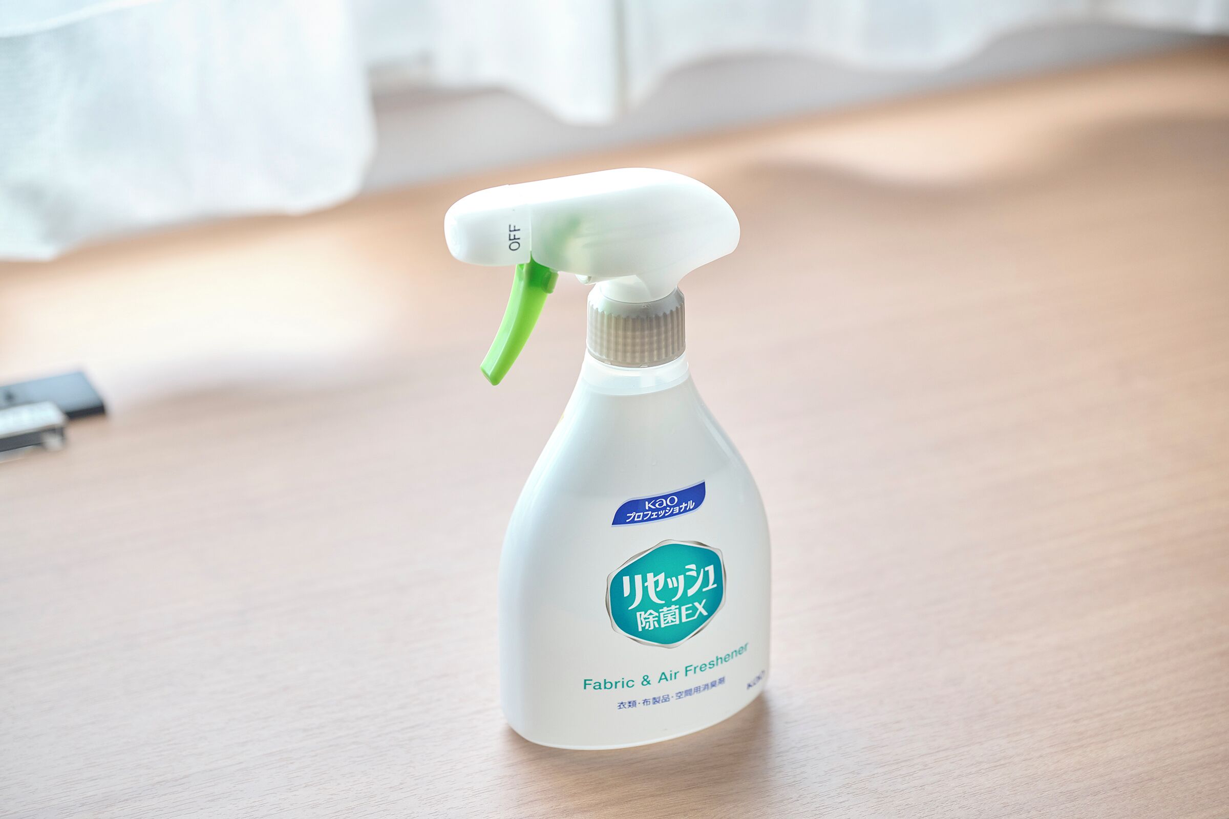En sprayflaske mærket 'Fabric & Air Freshener' på en træoverflade.