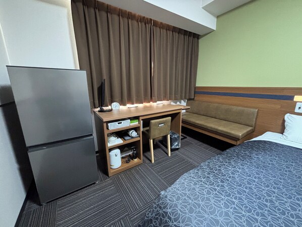 A hotel room with a bed, a desk with a computer, a refrigerator, a sofa, and a window with curtains. - Hotel 1-2-3 Kurashiki (Kurashiki)