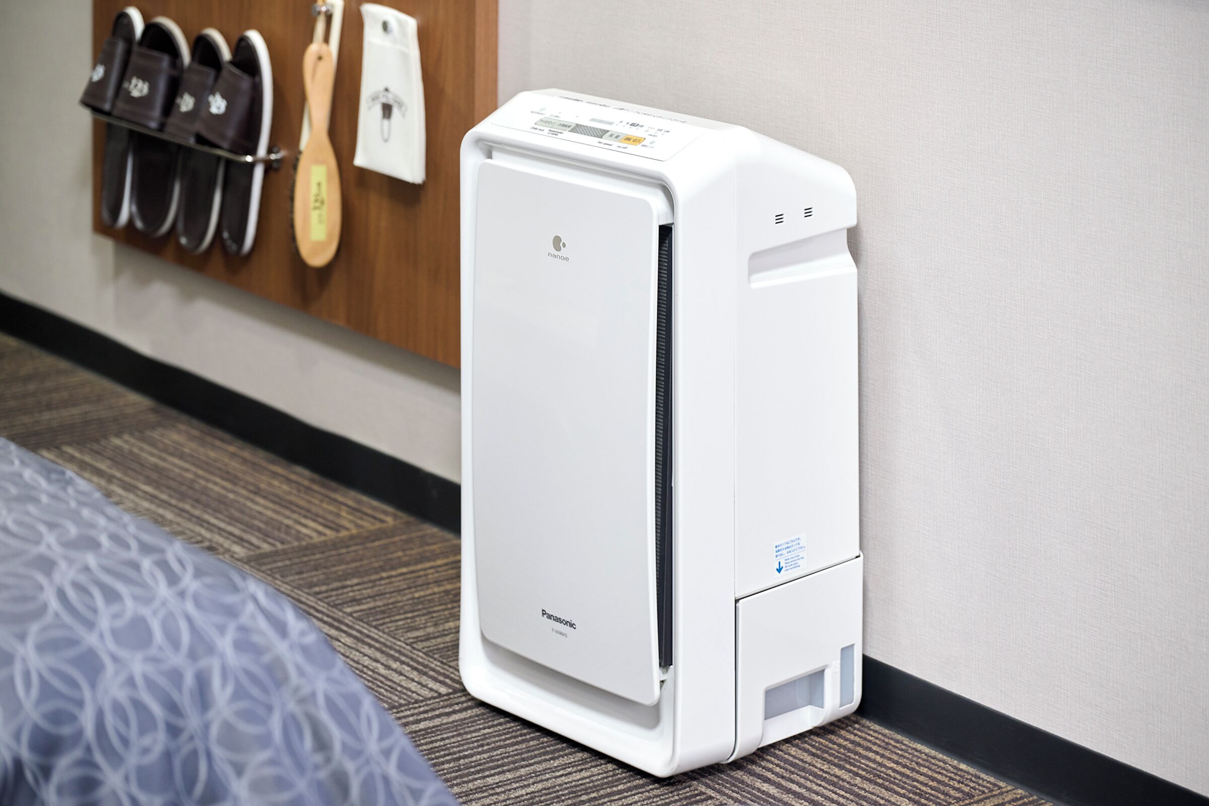 Un equipo de aire acondicionado Panasonic blanco en una habitación de hotel.