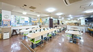 A cafeteria with multiple tables and chairs, a clock on the wall, and a window with posters. - Hotel 1-2-3 Kurashiki (Kurashiki)