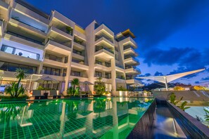 Um hotel moderno com piscina infinita no terraço, várias varandas e áreas de estar ao ar livre.