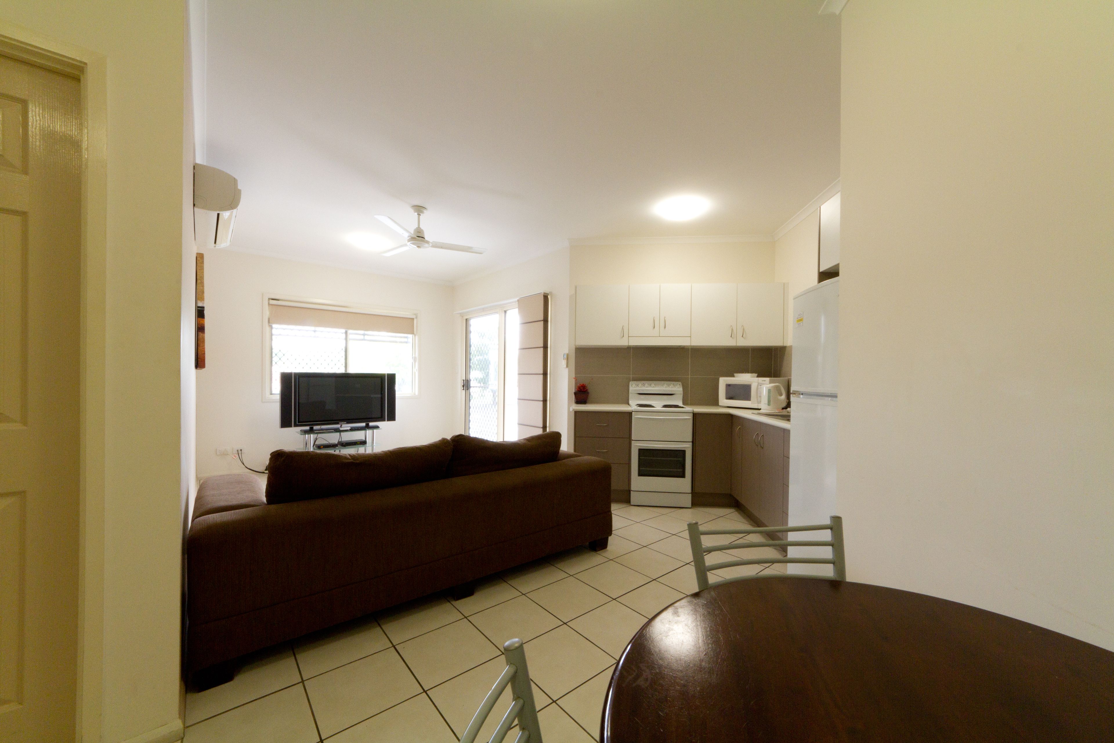 Un espacio habitable compacto con sofá, una mesa de comedor y kitchenette.