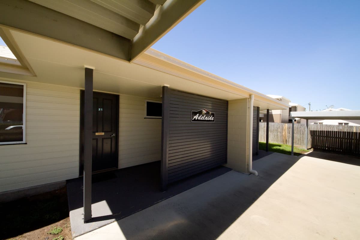 A residential building with a garage door labeled "The Adelaide."
