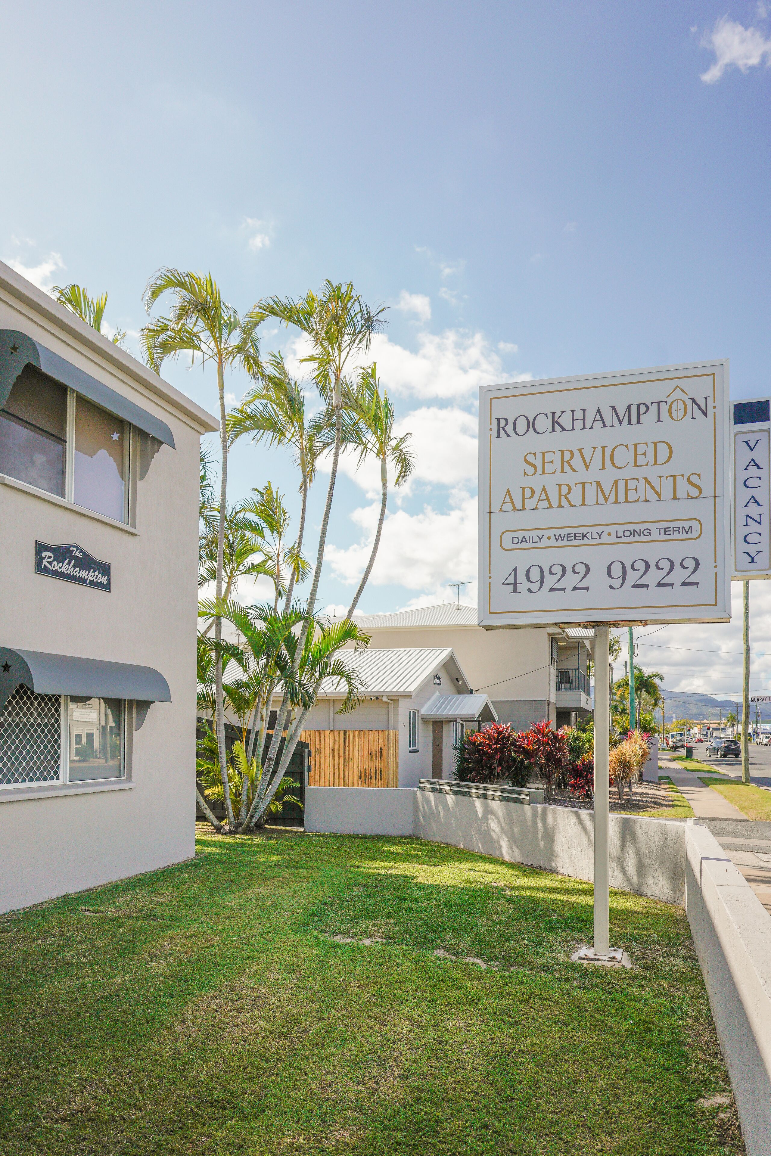 A sign for Rockhampton Serviced Apartments advertising daily, weekly, and long-term rental options.