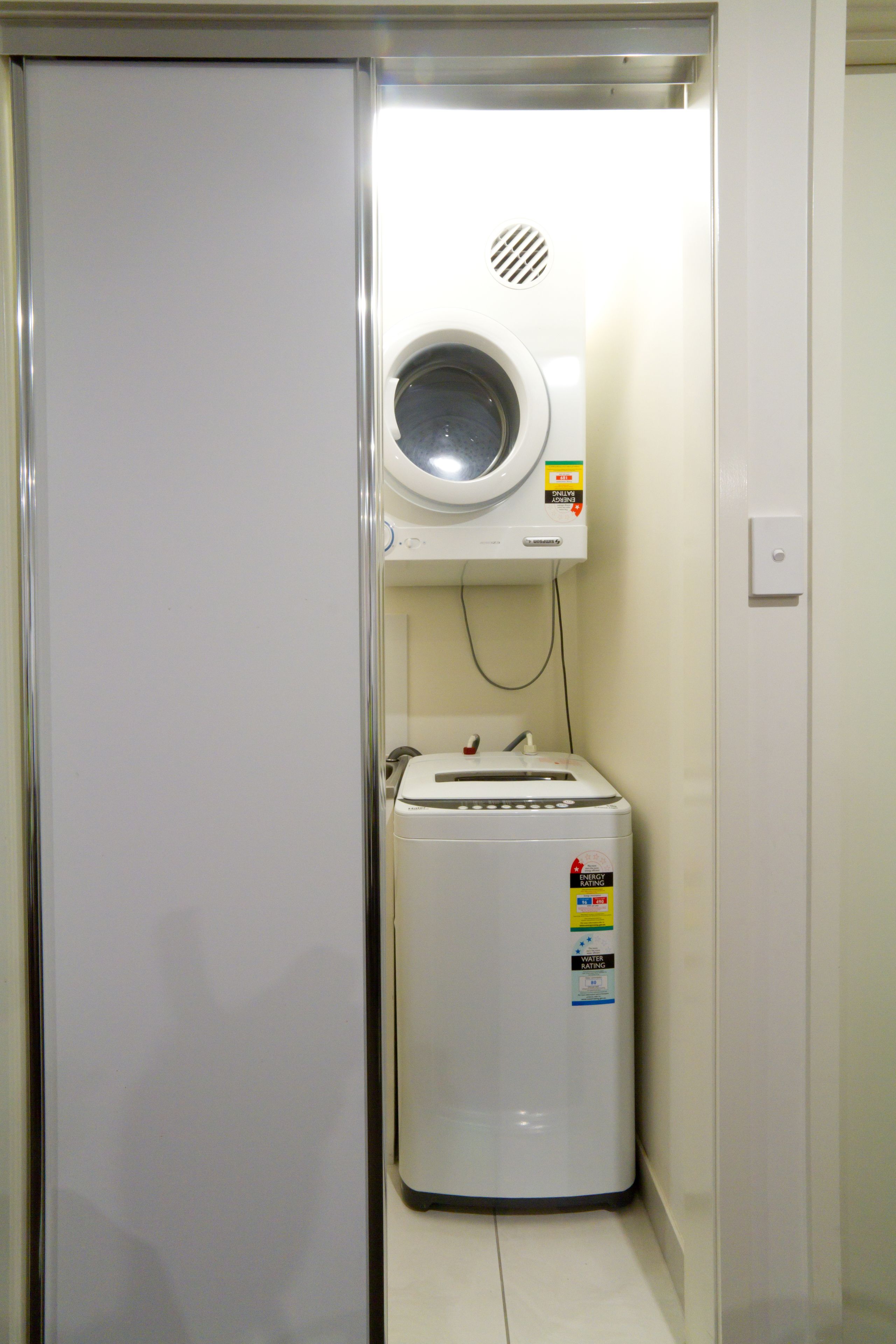 Une petite buanderie équipée d’un lave-linge et d’un sèche-linge.
