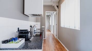 A modern kitchen with a black granite countertop, white cabinetry, and a built-in oven.