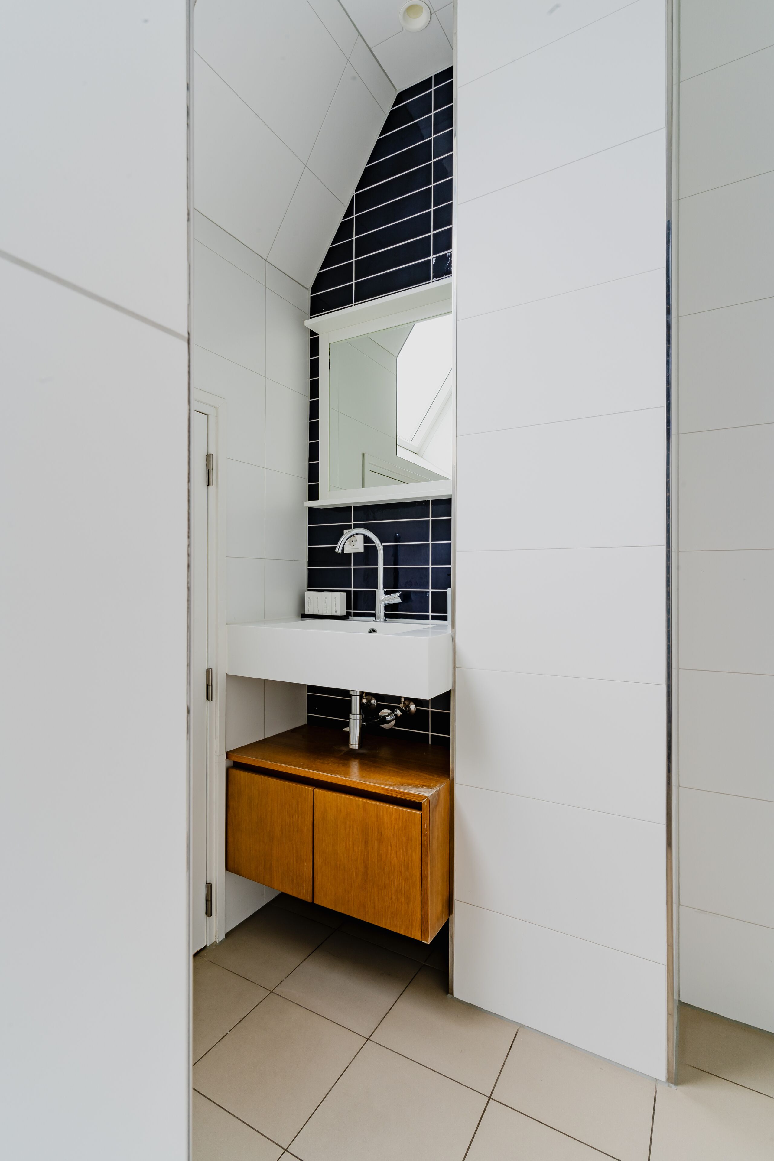 A bathroom with a white sink, a mirror, and a wooden cabinet.