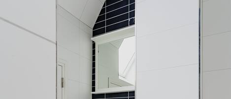 A bathroom with a white sink, a mirror, and a wooden cabinet.