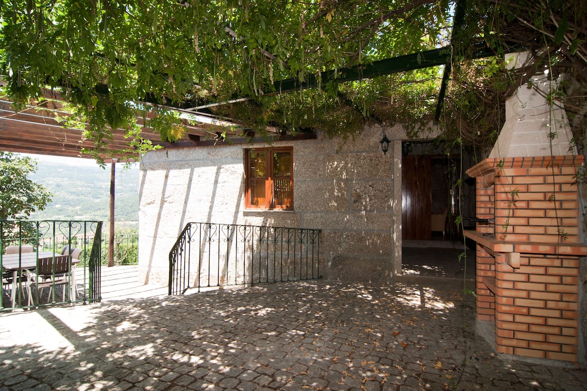 A stone building with a wooden door, a brick wall, and a metal railing.