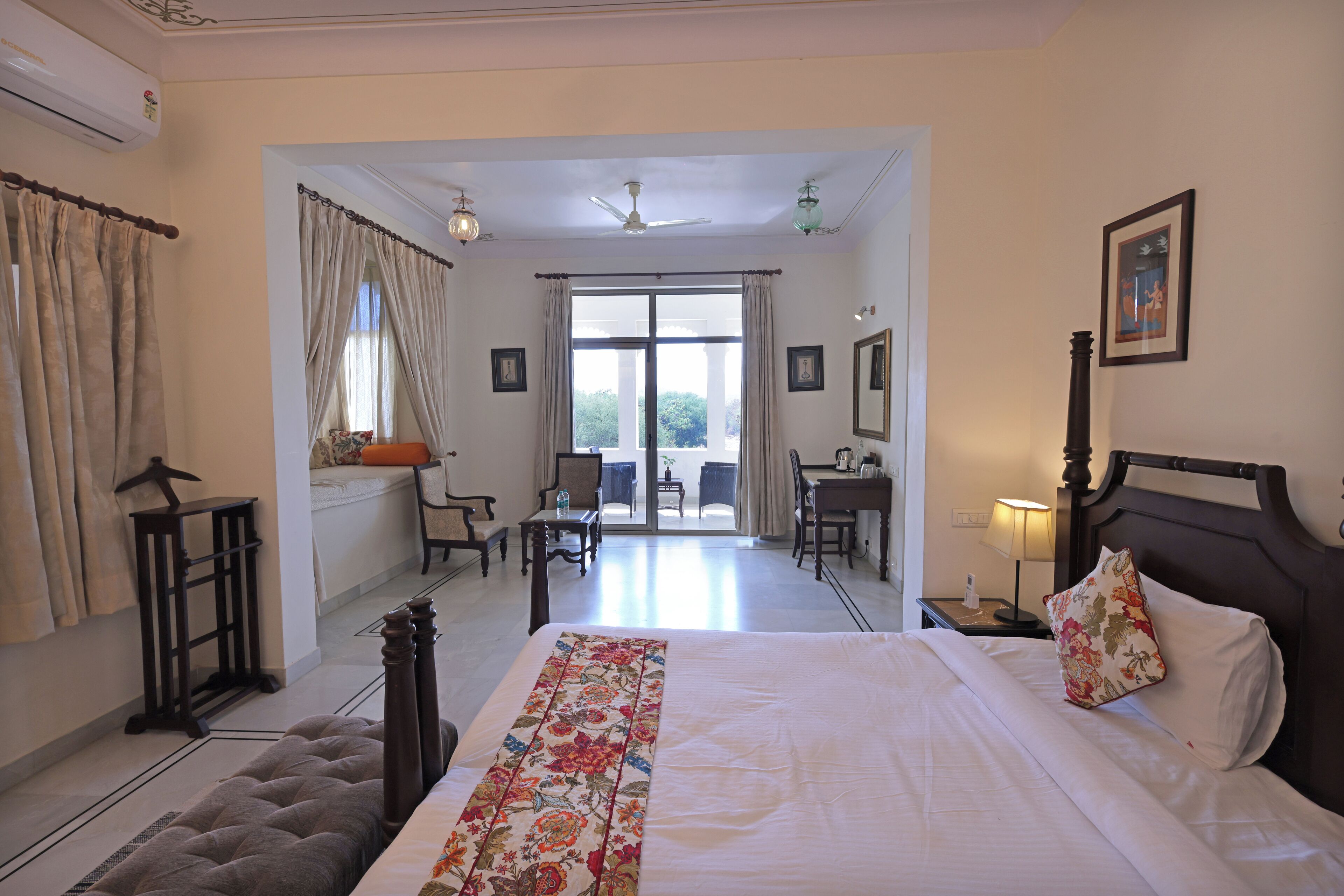 Habitación de hotel con una cama grande, un escritorio y vistas al exterior.