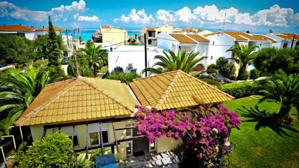 A residential area with houses featuring tiled roofs and lush green gardens. - Kapsohora Inn Hotel (Kassandra)