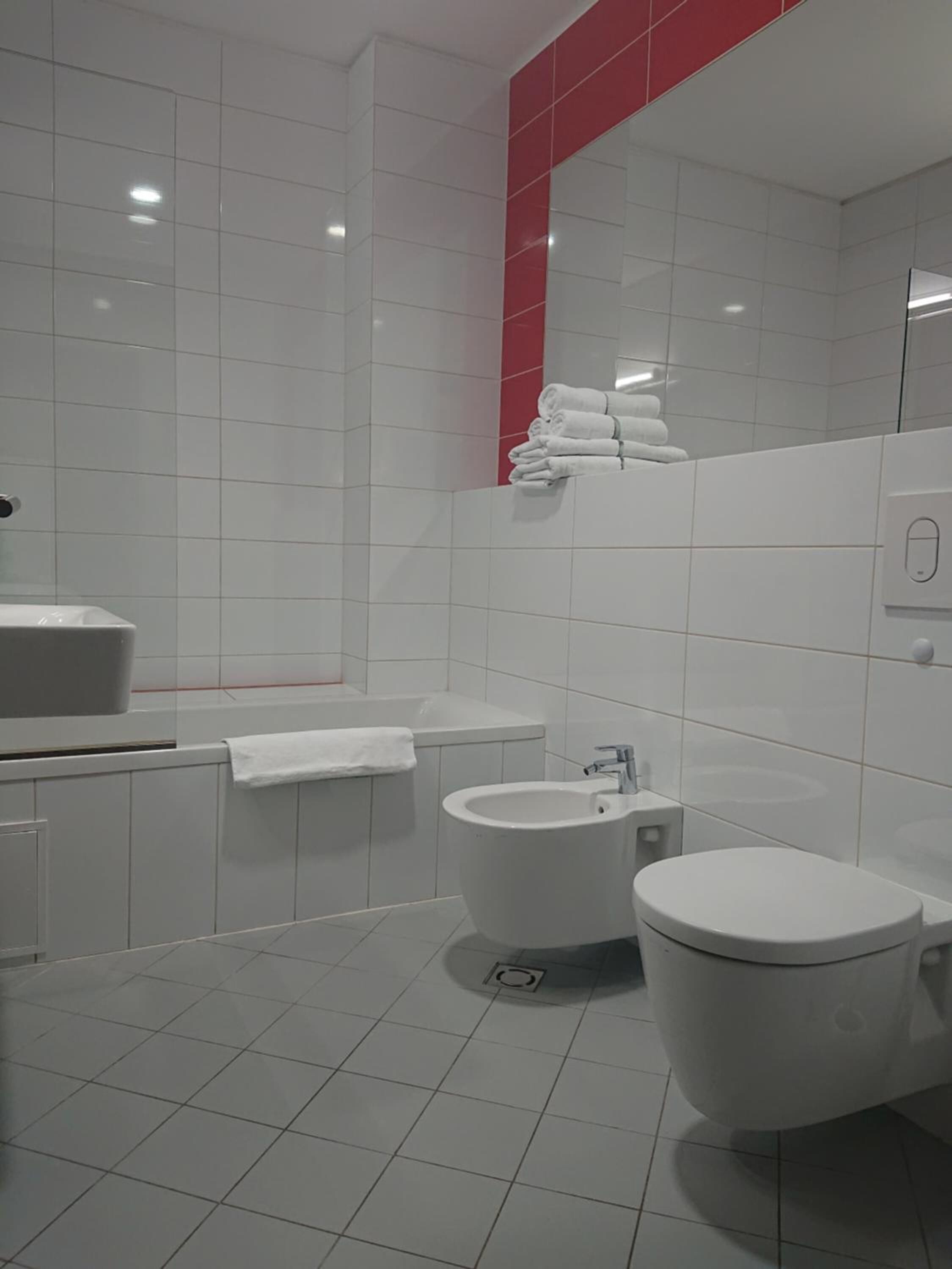 A modern bathroom with a toilet, bidet, and sink.