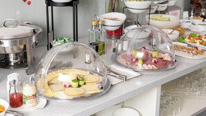 A buffet setup with various food items and condiments. - Algiro Hotel (Kaunas)