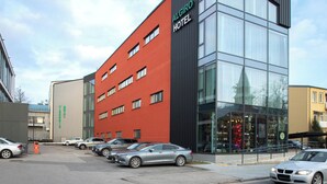 A modern hotel with a red facade and large windows. - Algiro Hotel (Kaunas)