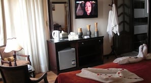 A hotel room with a bed, a desk with a computer, a TV mounted on the wall, and a chair. - Cairo plaza Guest House (Sheikh Zayed City)