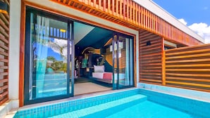 Un bâtiment moderne doté d’une piscine, de grandes portes vitrées et d’une terrasse en bois.