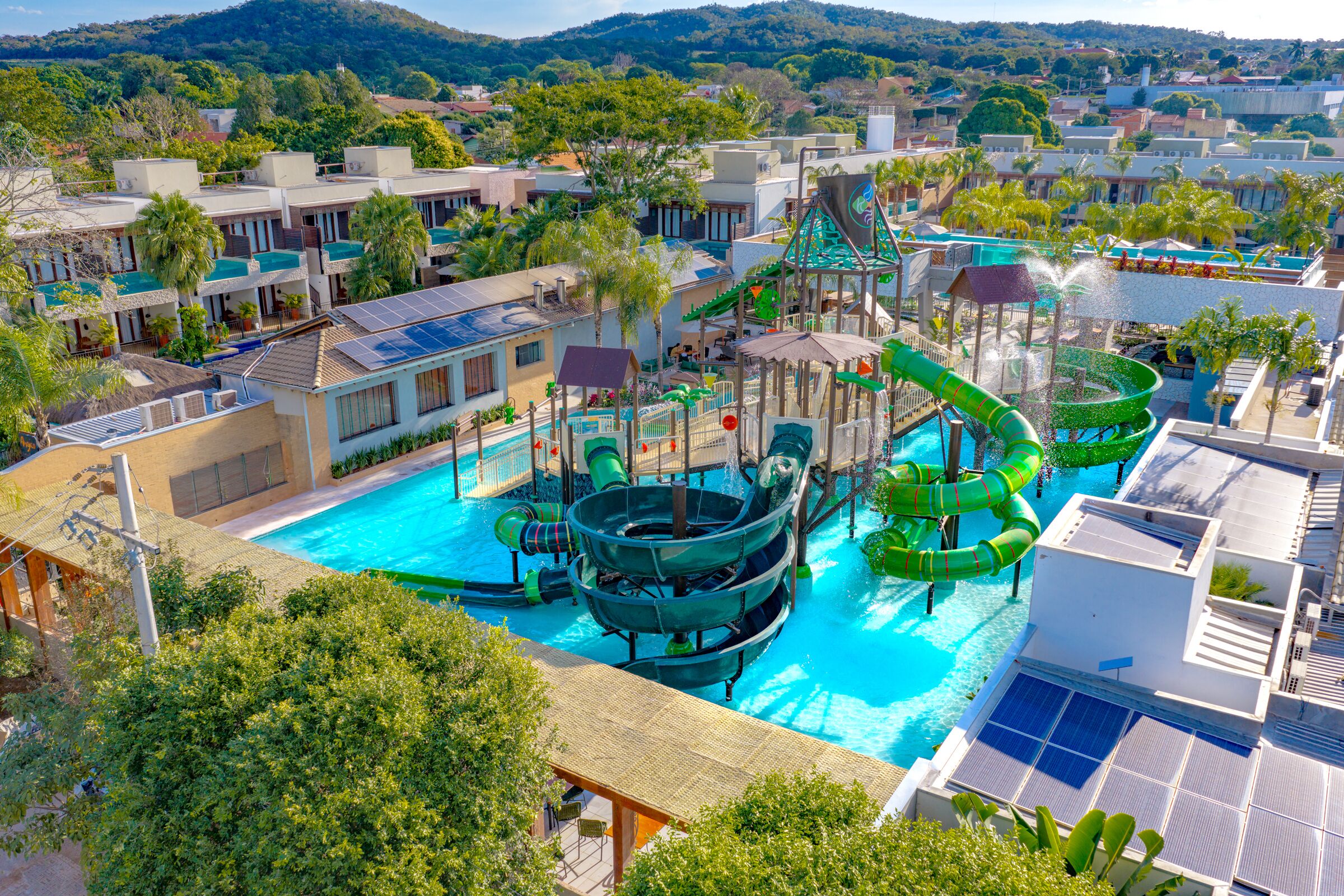 Um resort com uma grande piscina, toboáguas e painéis solares.