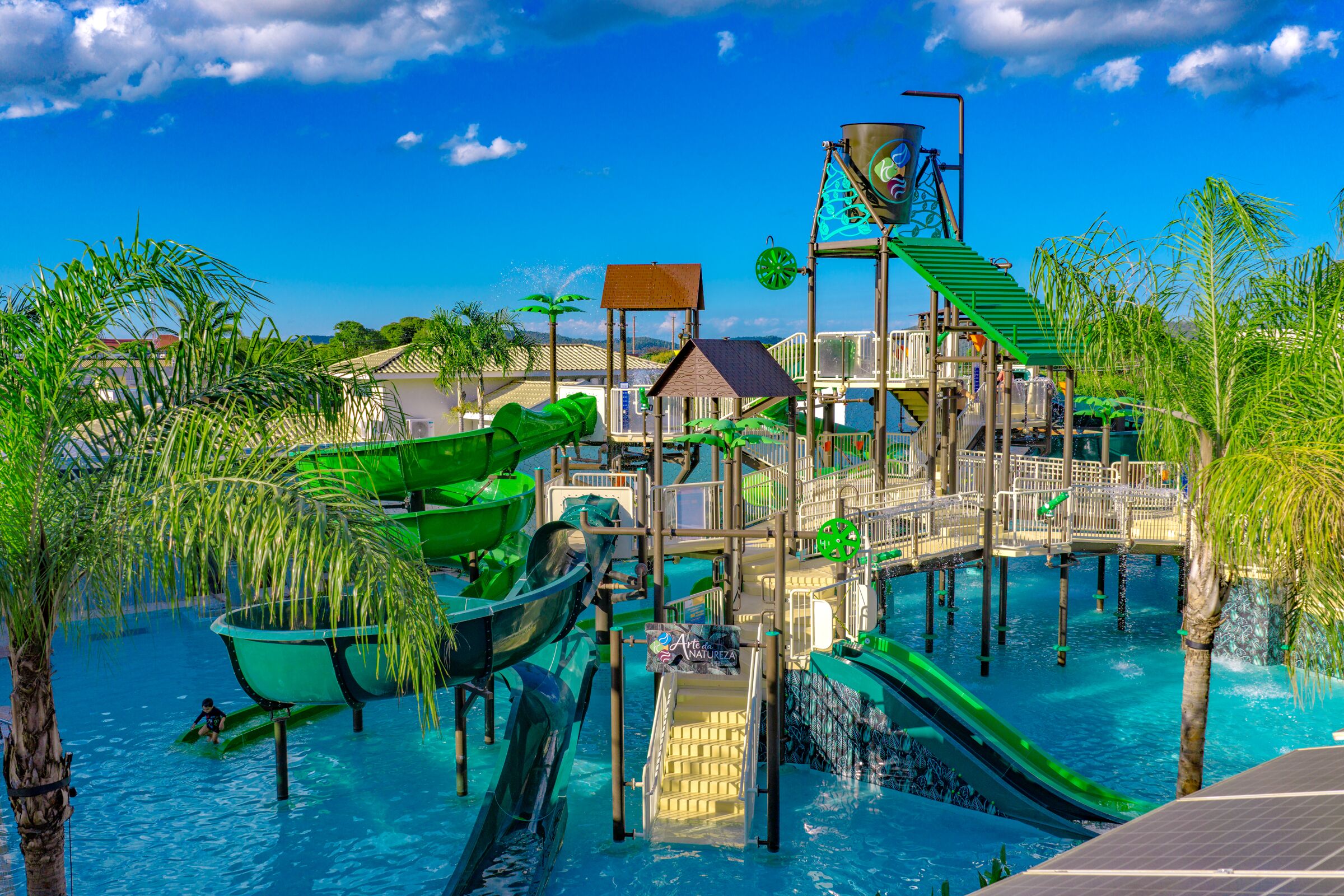 A water park with slides, a bridge, and a pool.