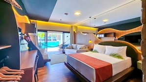 Une chambre d’hôtel moderne équipée d’un lit, d’un bureau, d’une chaise, d’un canapé et offrant une vue sur une piscine.