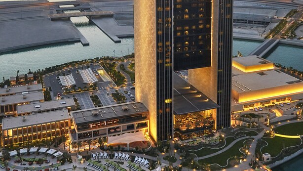 A high-rise hotel with a distinctive architectural design, featuring a central atrium and a waterfront pool area. - Four Seasons Hotel Bahrain Bay (Manama)