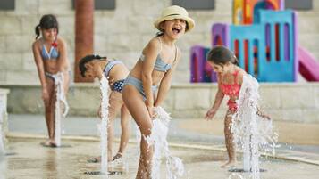 Un’area giochi con acqua, dotata di numerose fontane e strutture colorate sullo sfondo.