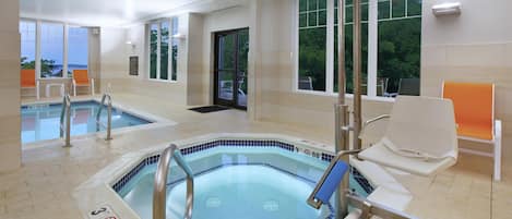 Un área de piscina con dos jacuzzis, un trampolín y vistas al exterior.