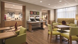 A modern hotel lobby with a coffee station, seating area, and a reception desk. - Hampton Inn Brigham City (Brigham City)