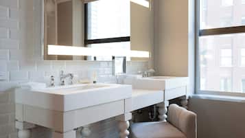 Un baño moderno con dos lavamanos, un espejo grande y una ventana que proporciona luz natural.