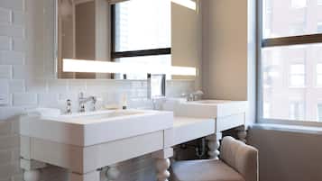 Un baño moderno con dos lavamanos, un espejo grande y un ventanal que proporciona luz natural.