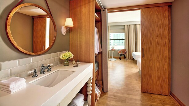 Ein Hotelbad mit einem großen Spiegel, einem Waschbecken und einem Waschtisch.