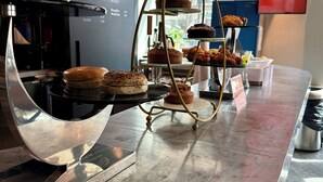 Eine Bäckertheke mit Gebäck und ein Café-Schild im Hintergrund.