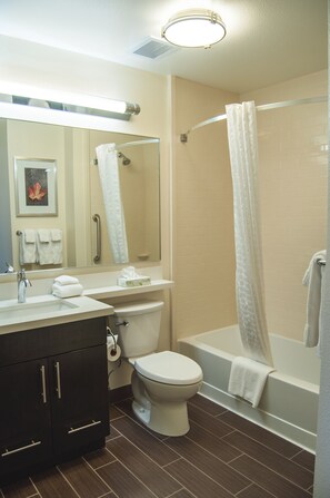 Een badkamer met een wastafel, toilet en bad.