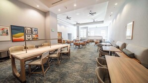 A conference room with multiple tables and chairs, ceiling fans, and artwork on the walls. - Homewood Suites by Hilton Rochester Mayo Clinic Area / Saint Marys (Rochester)