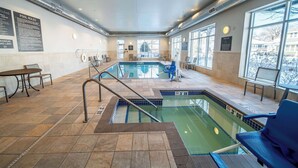 An indoor swimming pool with clear pool rules posted on the wall, a lifeguard chair, and a pool lift sign. - Homewood Suites by Hilton Rochester Mayo Clinic Area / Saint Marys (Rochester)