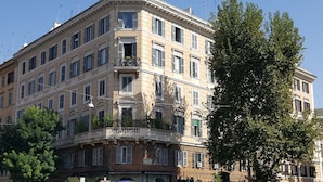 A multi-story building with a classical architectural style, featuring balconies and large windows. - Cesar Vatican Rooms (Rome)
