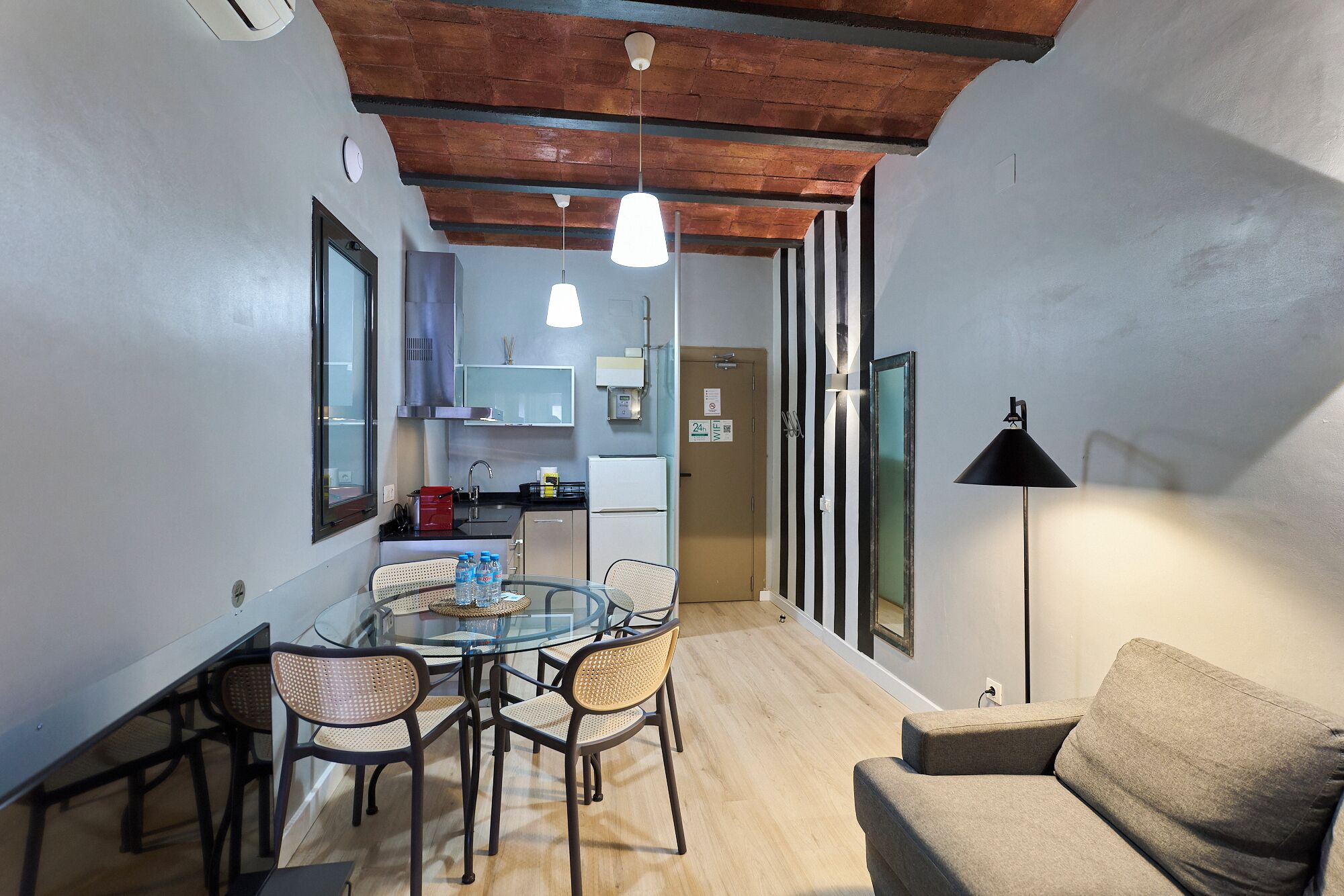 A compact living space with a dining area, kitchenette, and a sofa.