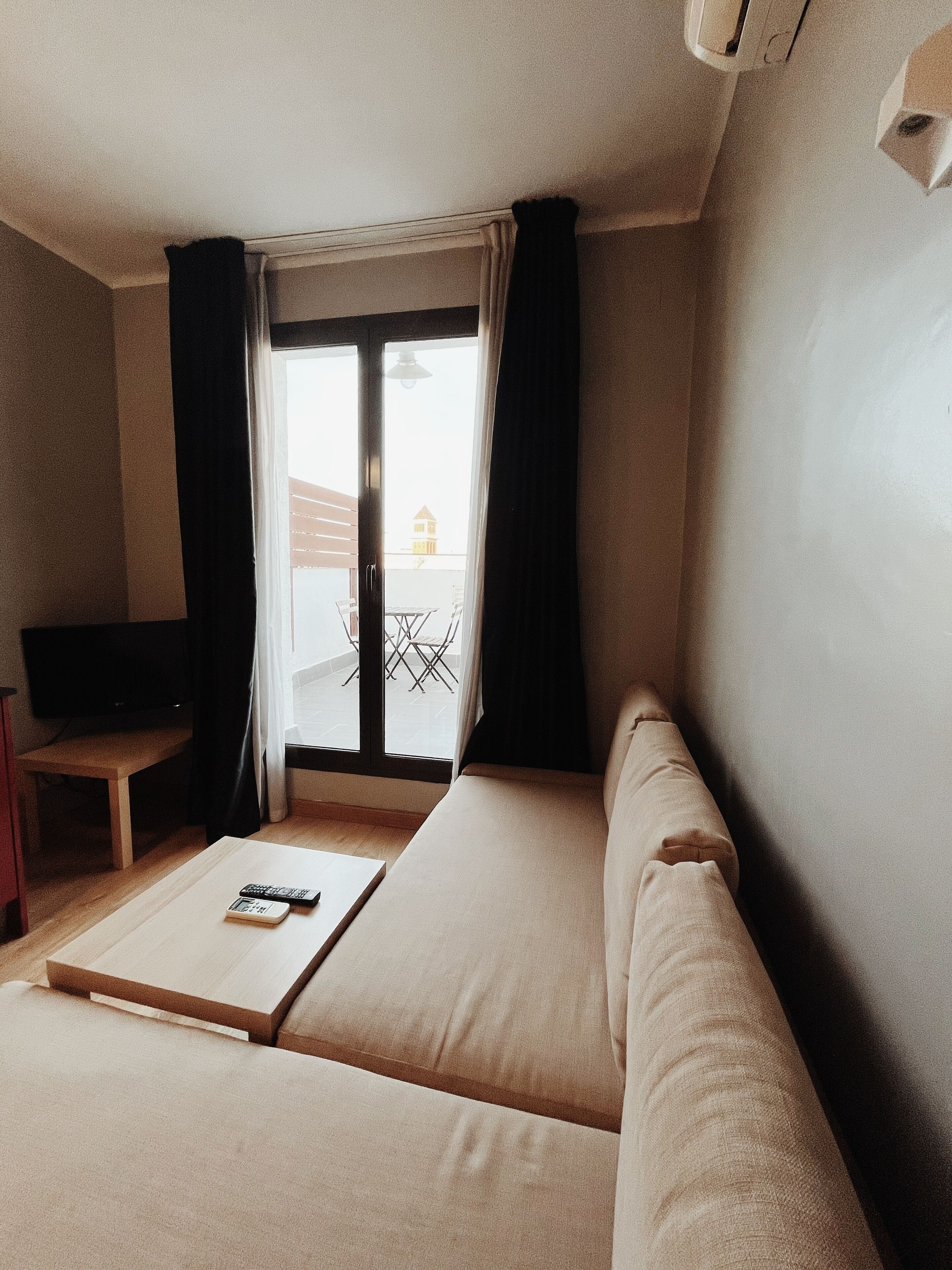 Una habitación con sofá, una mesita y un televisor.