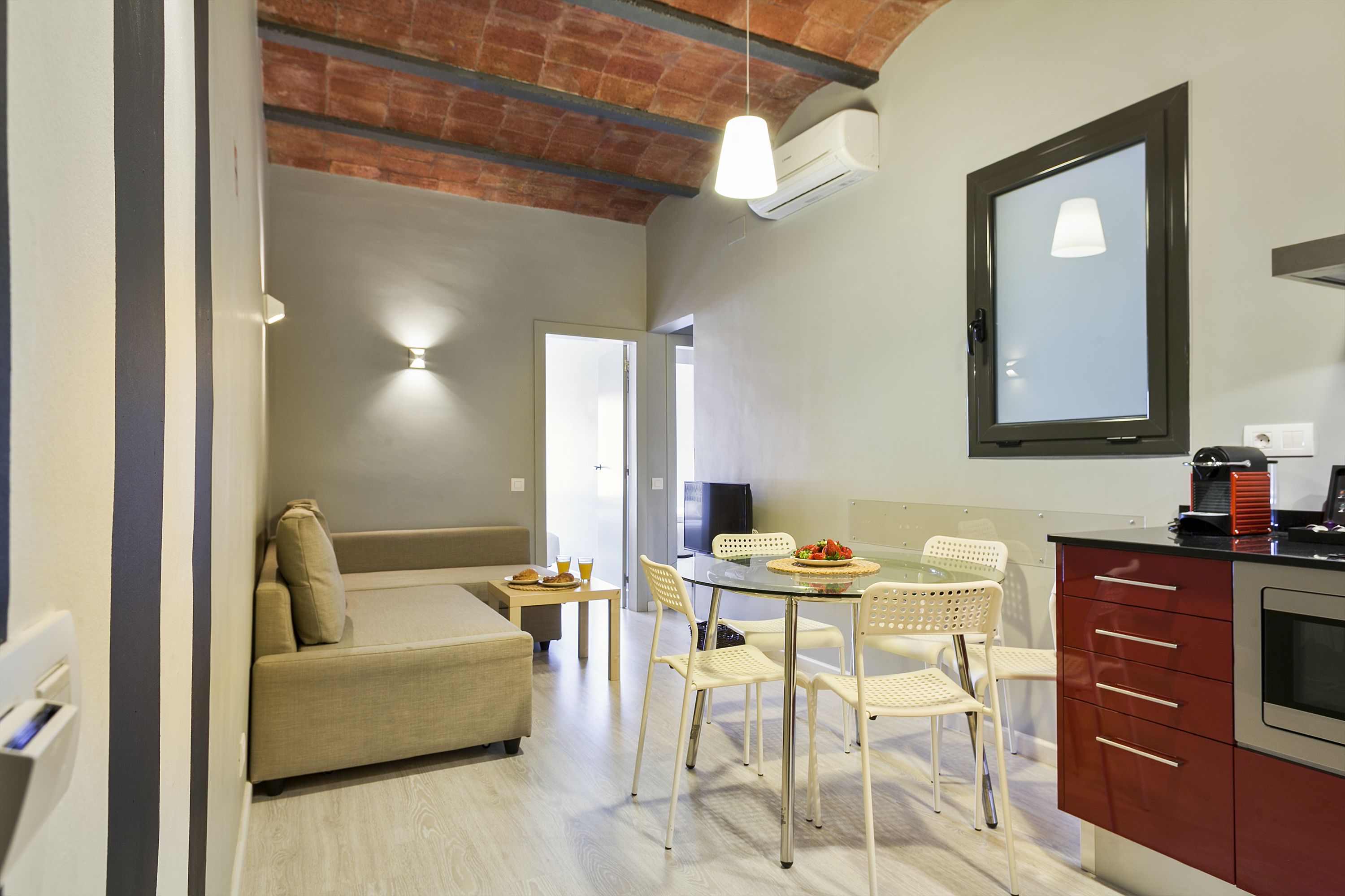 Una cucina moderna con zona pranzo, divano e televisore.