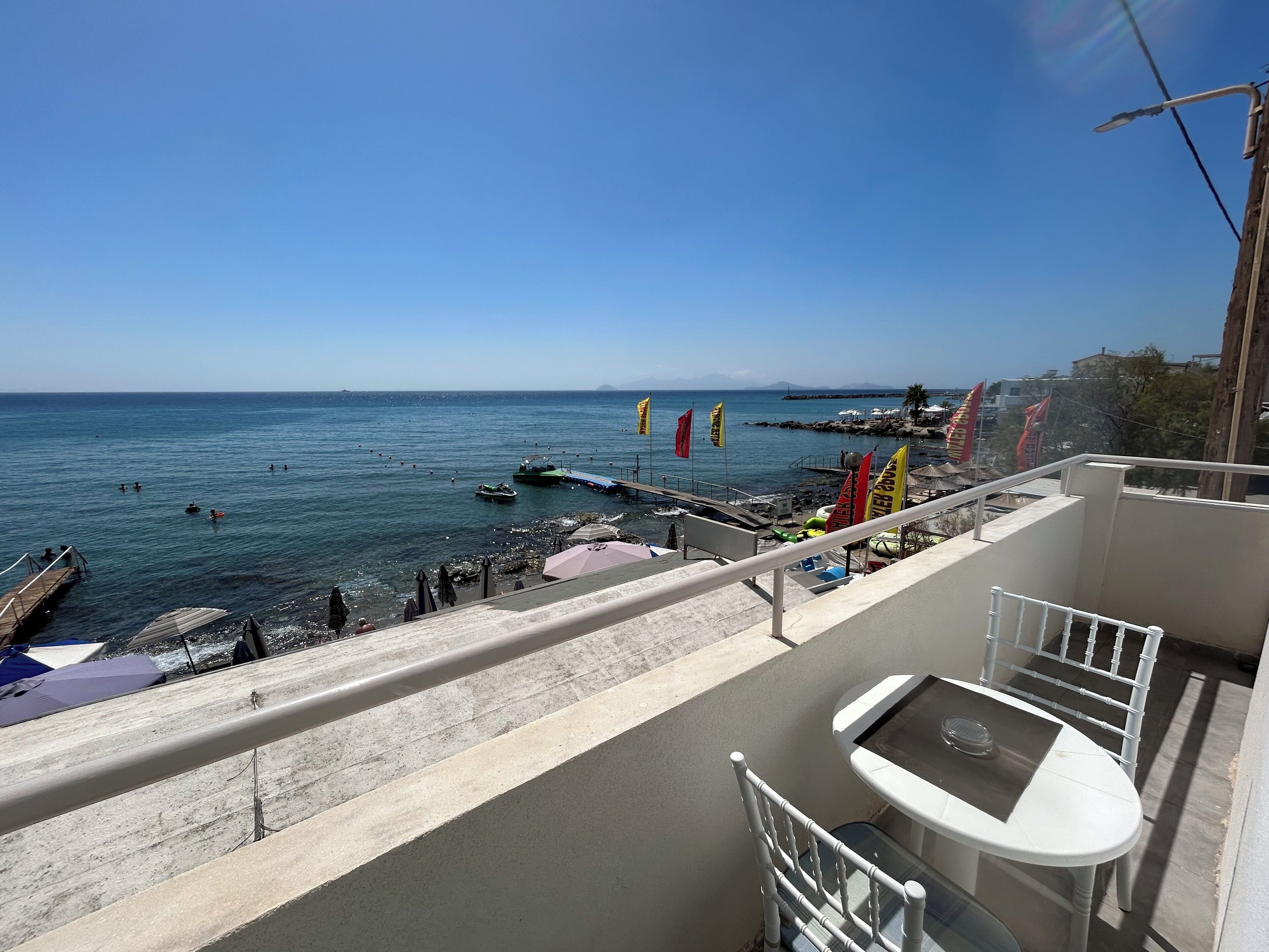 Ein Balkon mit Blick auf das Meer, inklusive Tisch und Stühlen.