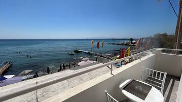 Ein Balkon mit Blick auf das Meer, inklusive Tisch und Stühlen.