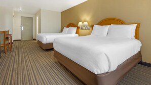 A hotel room with two beds, a carpeted floor, a wooden headboard, and a nightstand with a lamp. - Best Western East El Paso Inn (Clint)