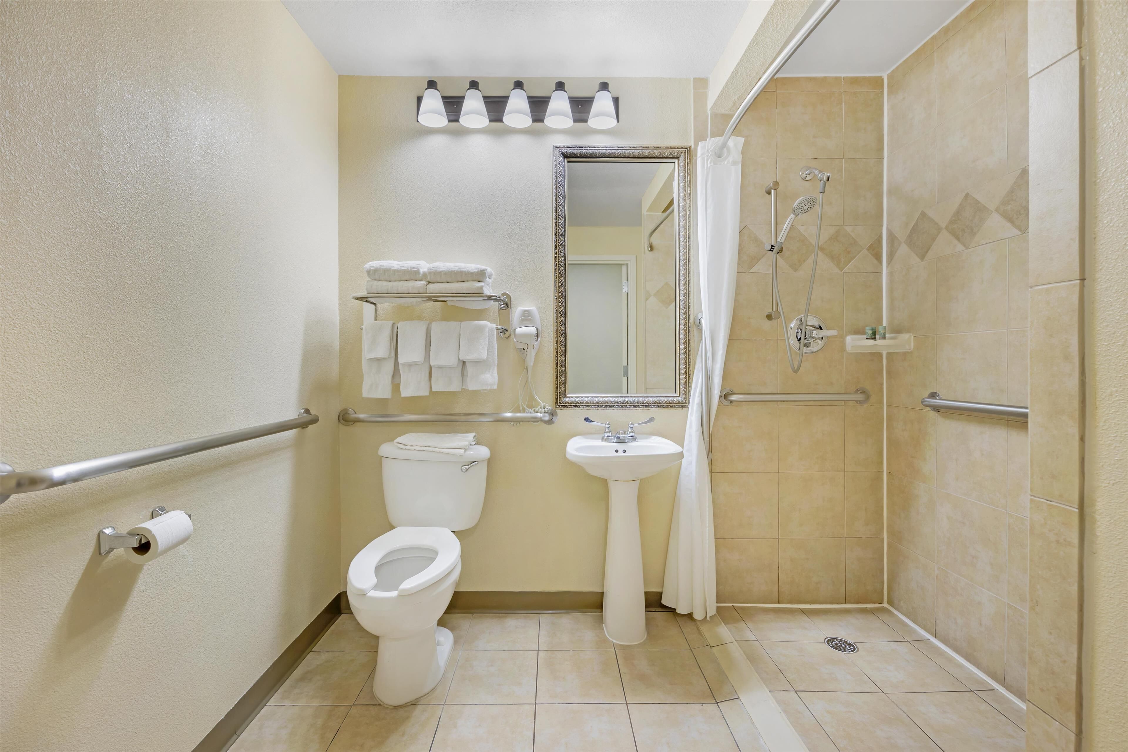 A bathroom with a toilet, sink, and shower.